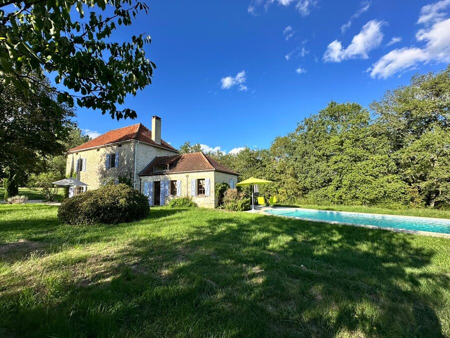 La maison et la piscine sous le ciel bleu à Dégagnac.